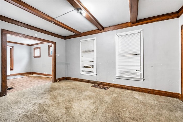 spare room with beam ceiling, light colored carpet, and ornamental molding