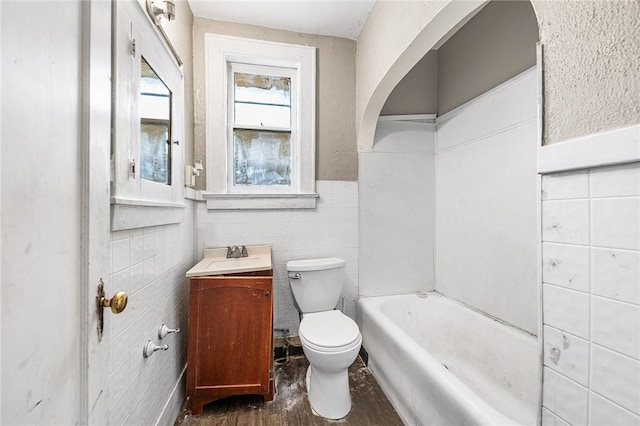 bathroom with a tub, hardwood / wood-style flooring, toilet, and vanity