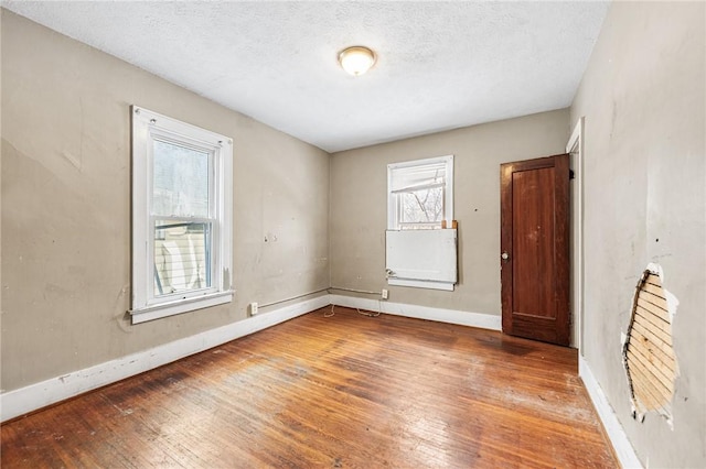 spare room featuring a textured ceiling and hardwood / wood-style flooring