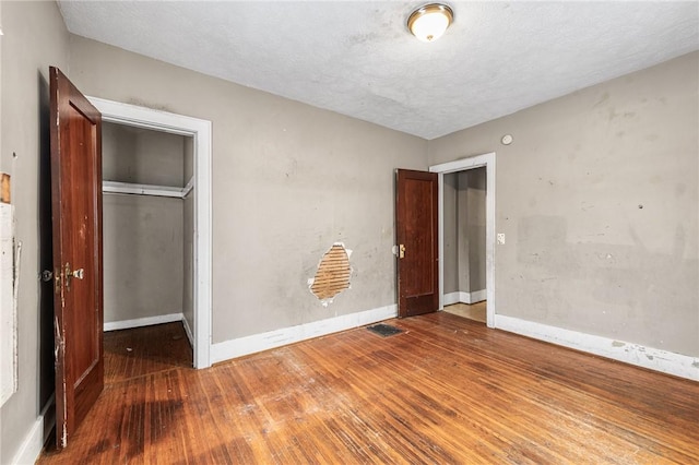 unfurnished bedroom with hardwood / wood-style floors and a closet