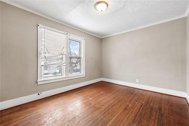 spare room featuring hardwood / wood-style floors, ornamental molding, and a textured ceiling