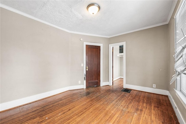 unfurnished room featuring a textured ceiling, dark hardwood / wood-style flooring, and ornamental molding