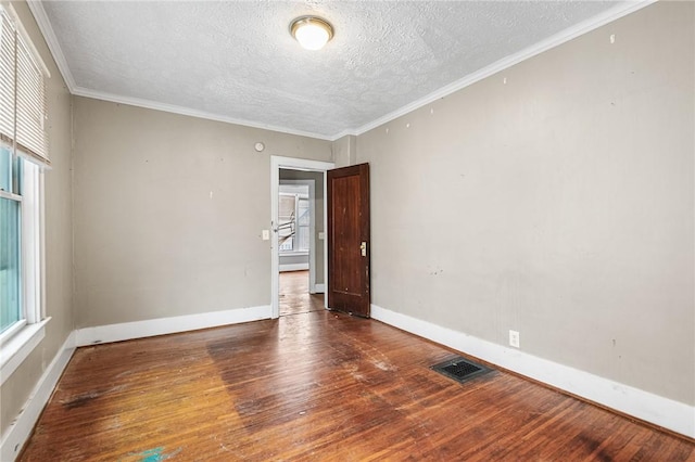 unfurnished room featuring dark wood-type flooring, crown molding, and a healthy amount of sunlight