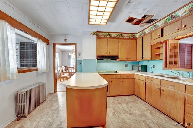 kitchen with radiator, a center island, black electric cooktop, and sink