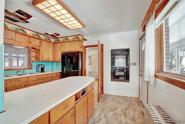 kitchen with radiator, sink, and black appliances