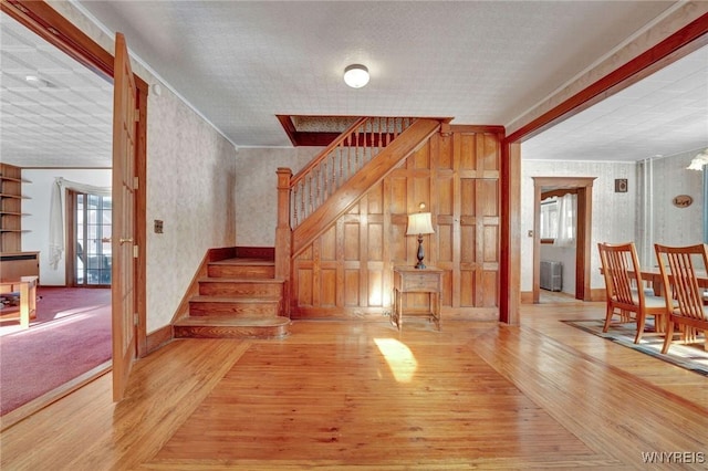 staircase featuring hardwood / wood-style floors, radiator, and ornamental molding