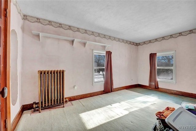 carpeted empty room with radiator heating unit