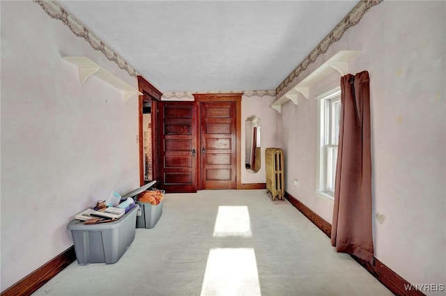 interior space featuring light carpet and radiator heating unit