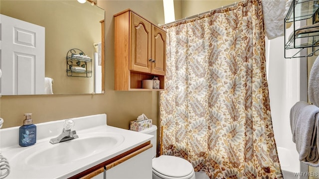 bathroom with toilet, vanity, and walk in shower