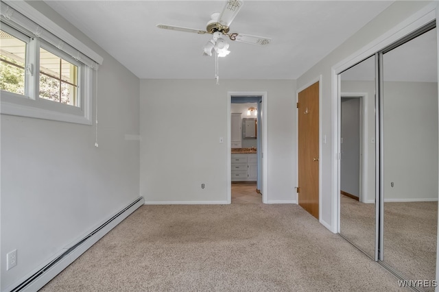 unfurnished bedroom featuring light carpet, ceiling fan, connected bathroom, a baseboard radiator, and a closet