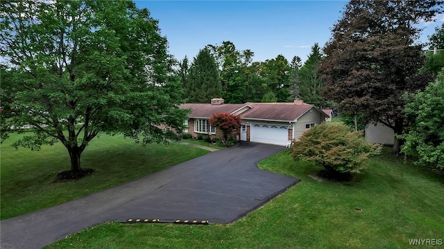 ranch-style house featuring a front yard and a garage