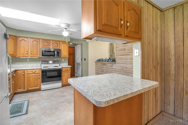 kitchen featuring ceiling fan, kitchen peninsula, white range with electric stovetop, and a skylight