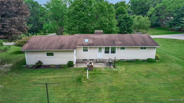 back of property with a lawn and a patio