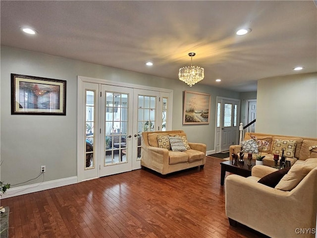 living room with dark hardwood / wood-style floors, french doors, and an inviting chandelier