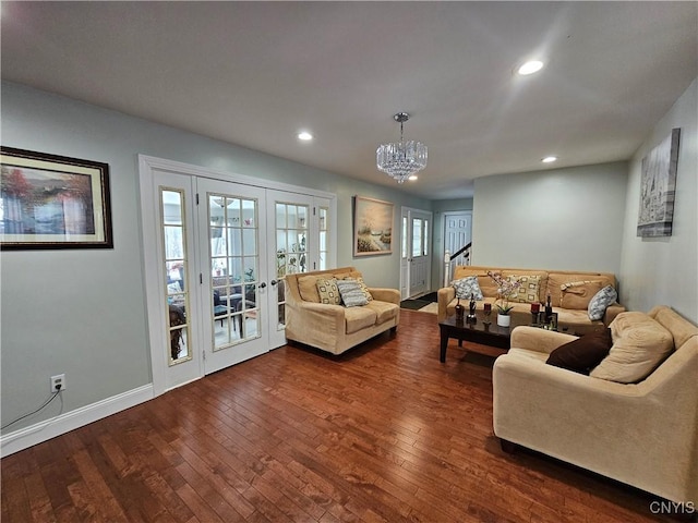 living room featuring dark wood-type flooring, a chandelier, and french doors