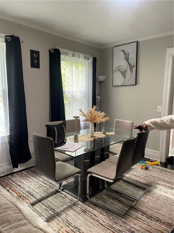 dining space with plenty of natural light, crown molding, and hardwood / wood-style floors