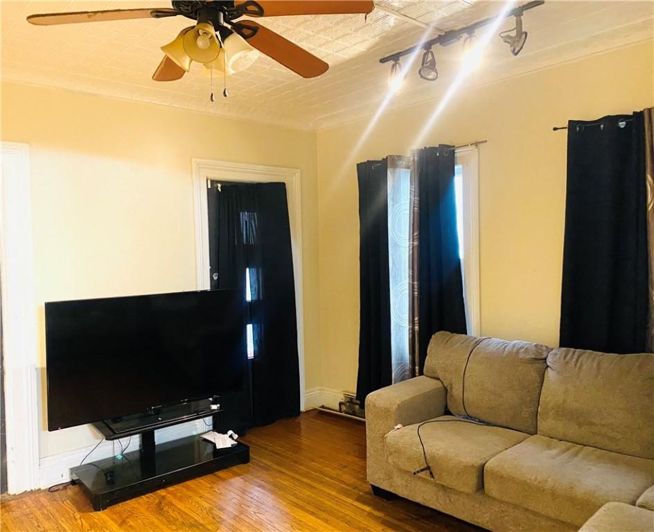 living room featuring ceiling fan, rail lighting, and wood-type flooring