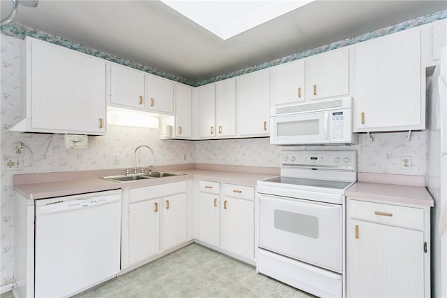 kitchen with white cabinetry, sink, and white appliances