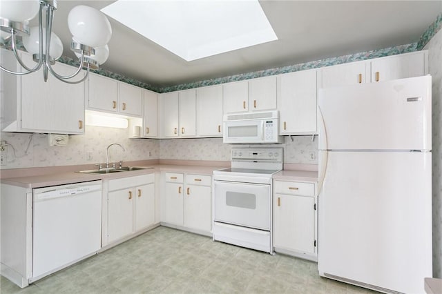 kitchen with sink, white appliances, and white cabinetry