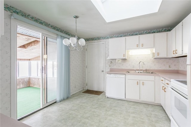 kitchen with white appliances, white cabinetry, sink, hanging light fixtures, and a chandelier