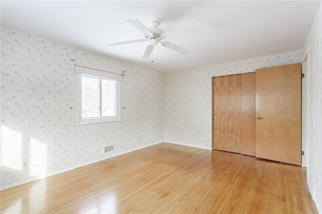 unfurnished bedroom with ceiling fan, light hardwood / wood-style flooring, and a closet