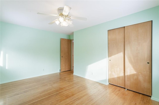 unfurnished bedroom with a closet, light hardwood / wood-style floors, and ceiling fan