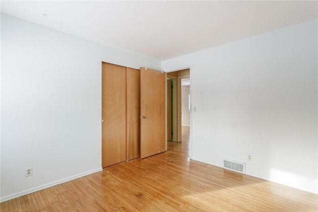 unfurnished bedroom featuring a closet and hardwood / wood-style flooring