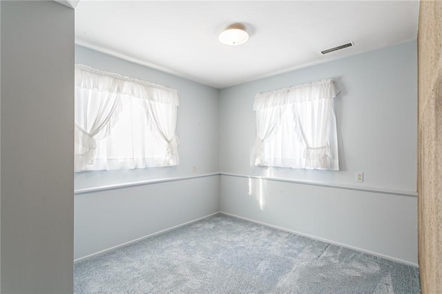 unfurnished room featuring a wealth of natural light and light colored carpet