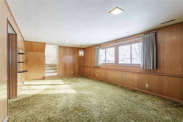 unfurnished room with carpet and wood walls