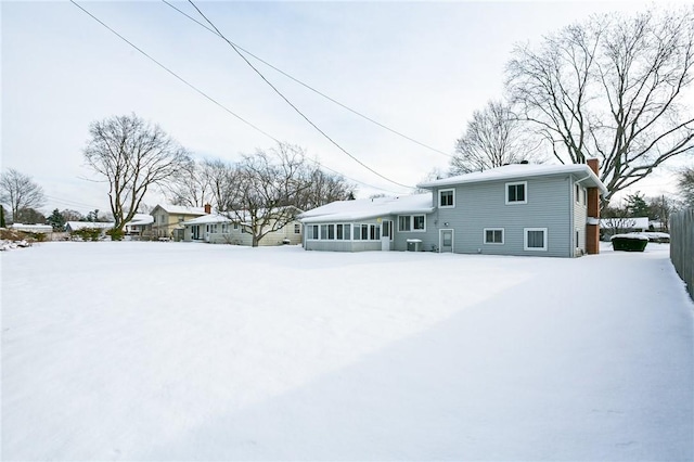 view of snow covered back of property