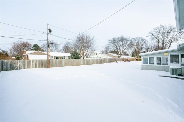 yard layered in snow with central air condition unit