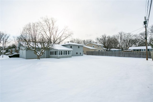 yard covered in snow with a sunroom