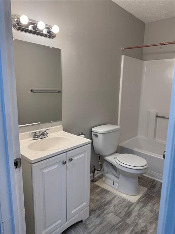 full bathroom with bathtub / shower combination, a textured ceiling, toilet, and vanity