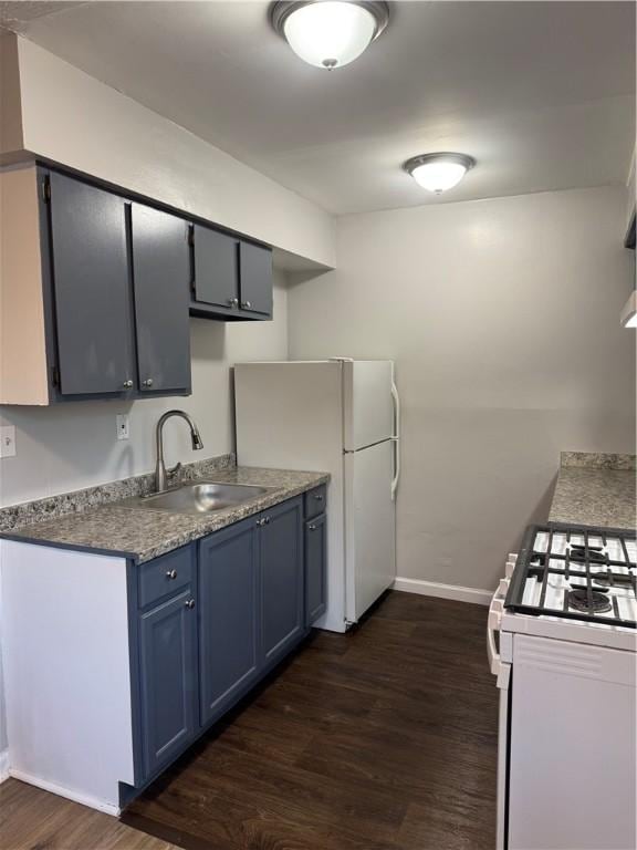 kitchen with dark hardwood / wood-style floors, white appliances, blue cabinetry, and sink