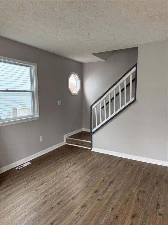 interior space featuring a textured ceiling and dark hardwood / wood-style floors