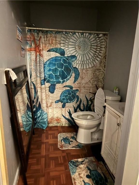 bathroom with toilet, parquet floors, and vanity