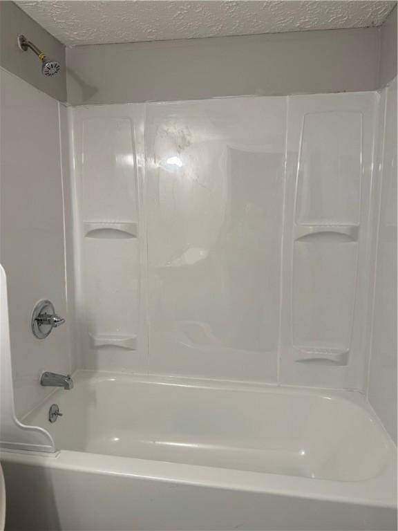 bathroom featuring shower / bath combination and a textured ceiling