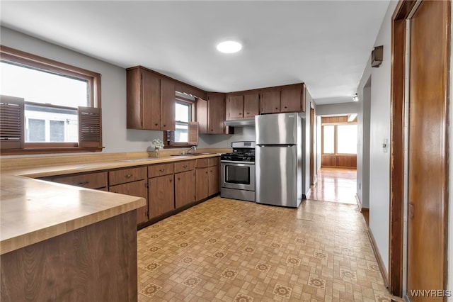 kitchen with appliances with stainless steel finishes, a healthy amount of sunlight, and sink