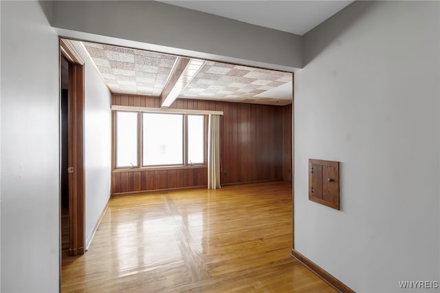 spare room featuring beamed ceiling and wood walls