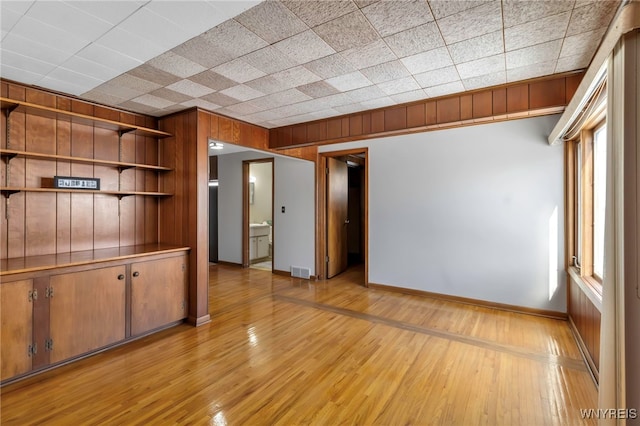 interior space with light hardwood / wood-style floors and wood walls