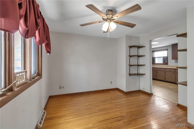 empty room with light wood-type flooring and ceiling fan