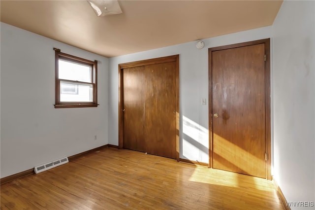 unfurnished bedroom featuring light hardwood / wood-style flooring and a closet