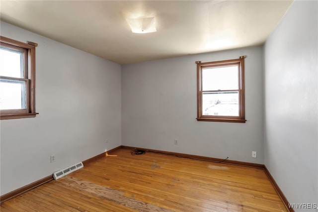 unfurnished room featuring light wood-type flooring and a healthy amount of sunlight