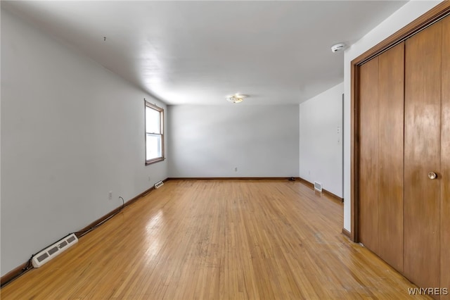 unfurnished bedroom with light wood-type flooring and a closet