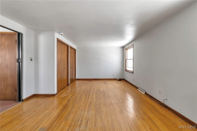 unfurnished bedroom with light wood-type flooring and a closet