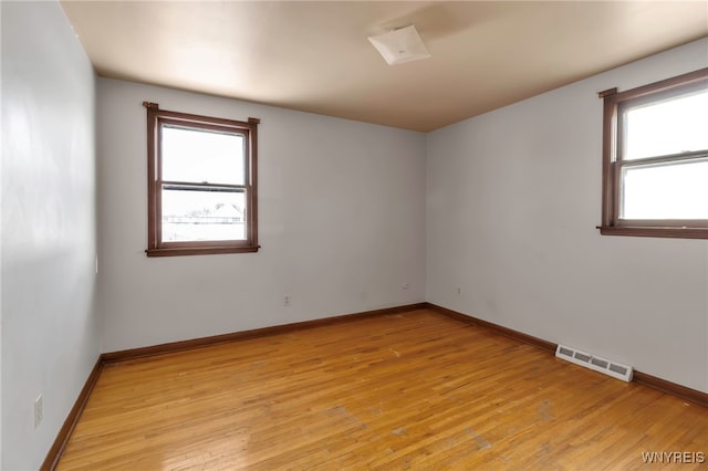 spare room featuring a healthy amount of sunlight and light hardwood / wood-style flooring