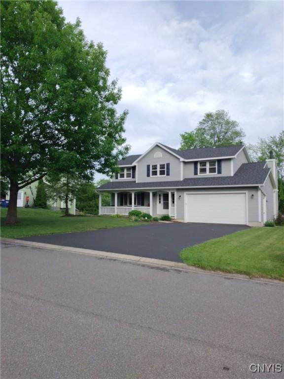 view of front of home with a front lawn, a porch, and a garage