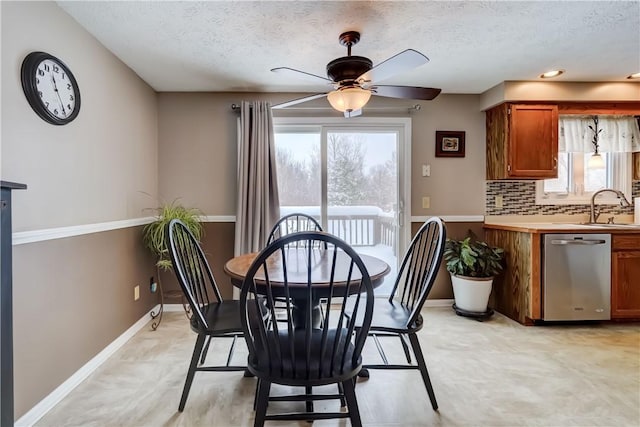 dining room featuring ceiling fan, sink, and a textured ceiling