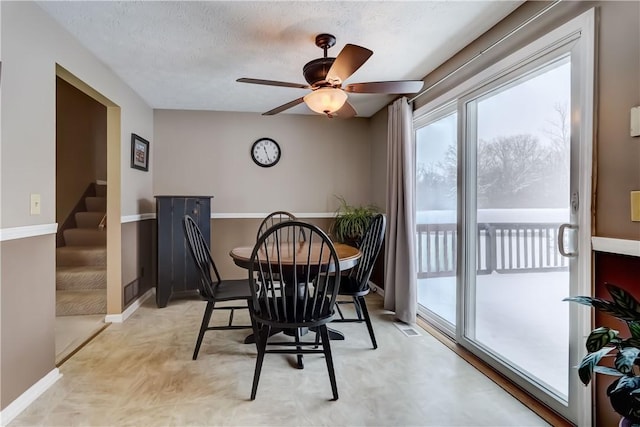 dining room with a textured ceiling and ceiling fan