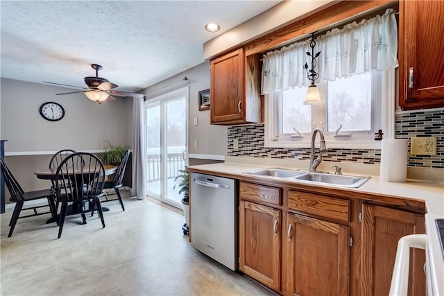 kitchen with ceiling fan, decorative backsplash, pendant lighting, stainless steel dishwasher, and sink